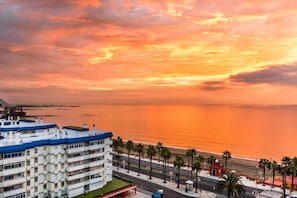 Eine Küstenstadt mit einem markanten Gebäude mit Balkonen und Blick auf das Meer.