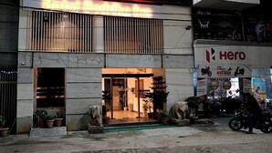 Un hotel con un letrero de neón, una tienda y una sucursal de Hero al otro lado de la calle.