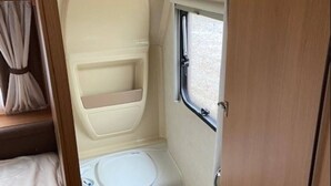 A compact bathroom with a toilet, sink, and a window. - Belgian Ardennes lovely 4-person caravan (Saint-Hubert)