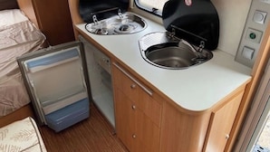 A compact kitchenette with two gas stoves, a sink, and a small refrigerator. - Belgian Ardennes lovely 4-person caravan (Saint-Hubert)