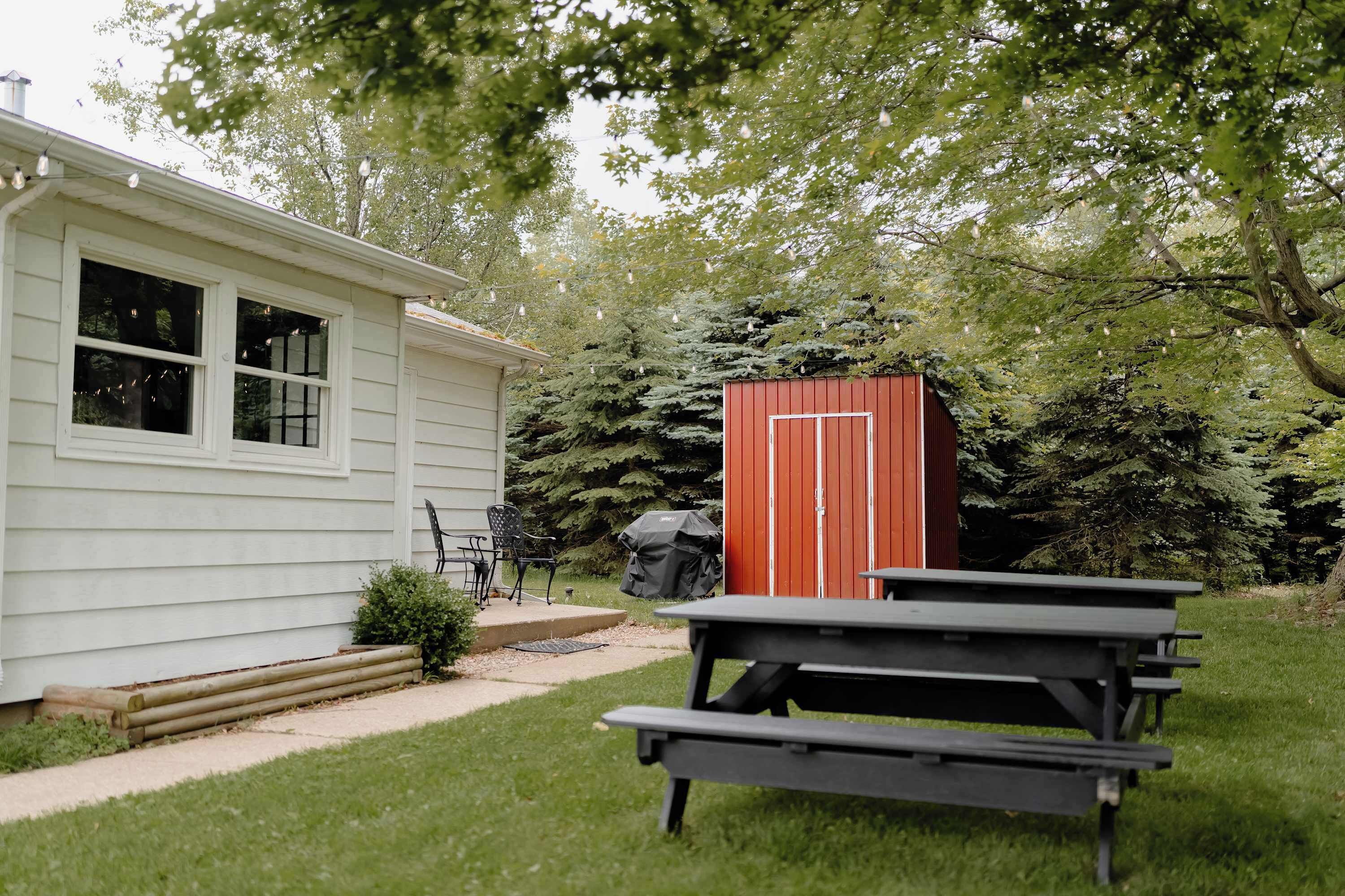 A house with a patio, a red shed, and a picnic table.