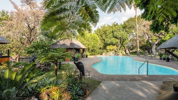 Una piscina al aire libre, sillones reclinables de piscina