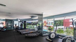 A gym with treadmills, elliptical machines, and weight equipment. - Apto pé na areia na Riviera São Lourenço (Bertioga)