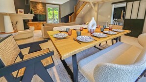 Un comedor moderno con una mesa de madera dispuesta para cuatro personas, rodeado de asientos cómodos.