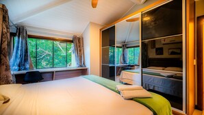 Un dormitorio con una cama grande, un armario y una ventana con cortinas.