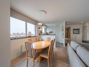 Un appartement moderne comprenant un coin repas, une cuisine et un espace de vie.