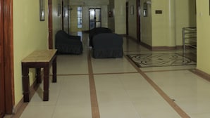Un hall d’entrée spacieux, doté d’un banc, d’un ventilateur de plafond et d’un sol à motifs.