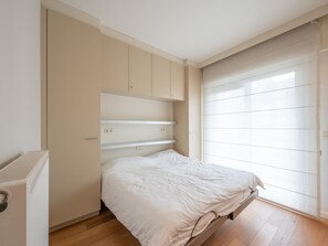 Un dormitorio con cama, espacio de almacenamiento integrado y puerta corredera.
