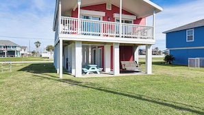 A two-story house with a balcony, a picnic table, and a swing set. - Walk to Beach: Galveston Home w/ Patio & Balcony! (Galveston)