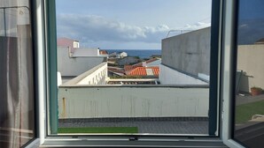 A view from a window overlooking a rooftop with a clear sky and distant sea. - Lagoa SEA View by Vacationy (Lagoa)