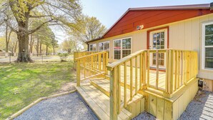 A wooden cabin with a porch and a red roof, surrounded by trees. - Walk to Beach: Eufaula 'fishermans Delight' Home (Eufaula)