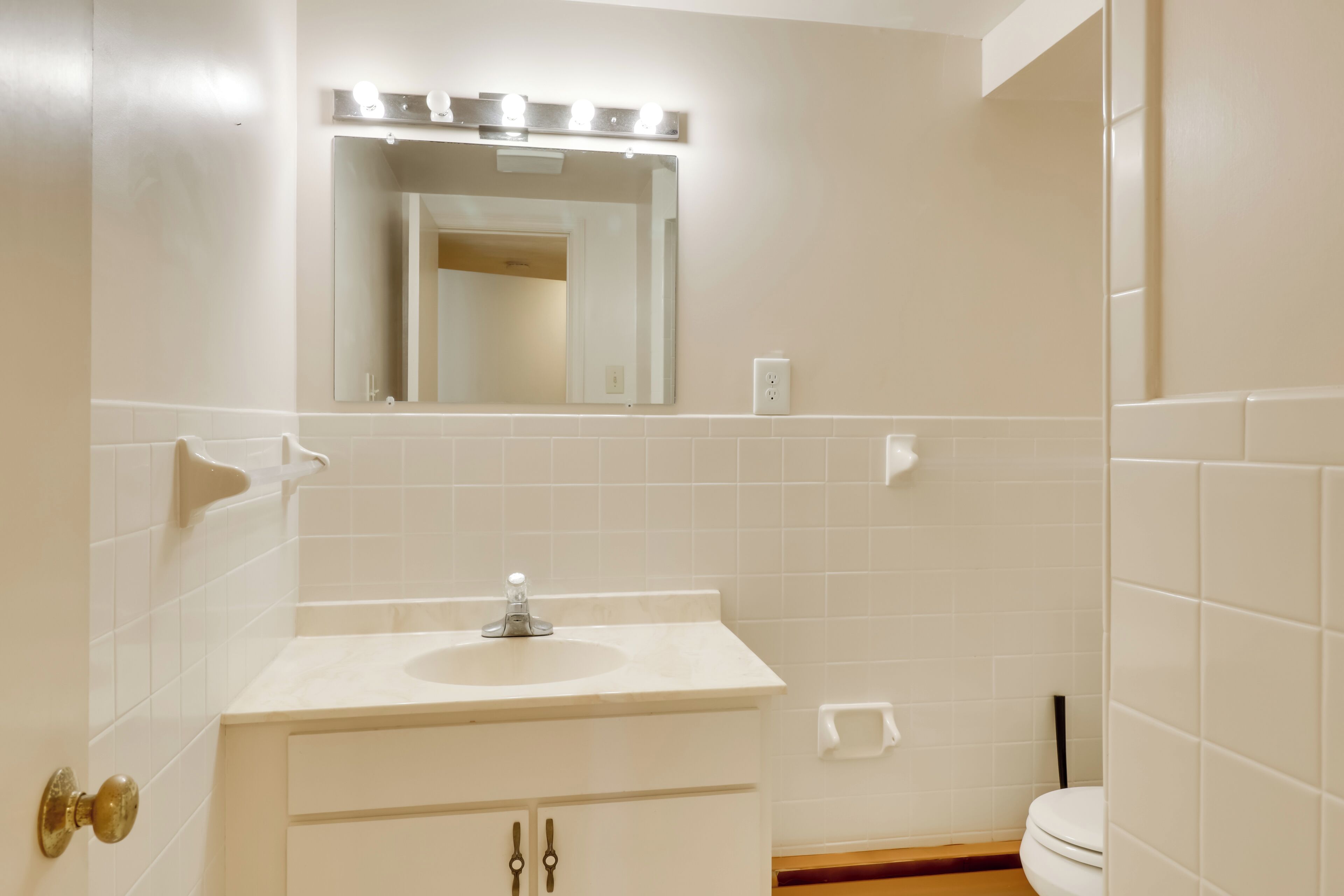 Un baño con lavamanos, espejo y retrete.
