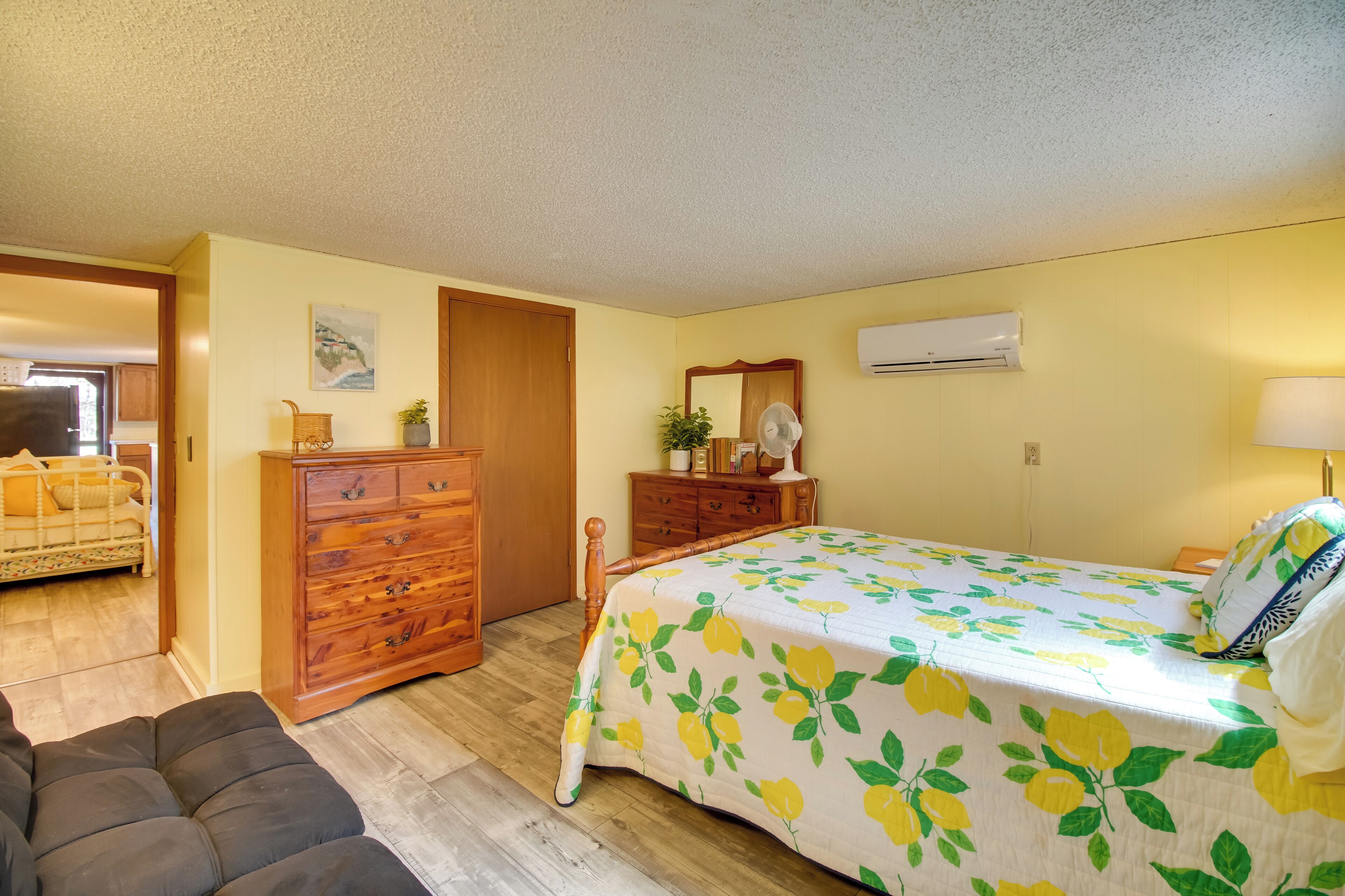 Un dormitorio con cama, cómoda y un pequeño rincón de descanso.