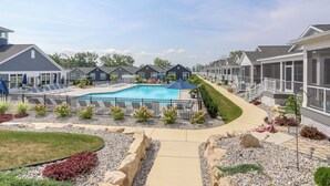 A residential area with a swimming pool, lounge chairs, and a well-maintained garden.