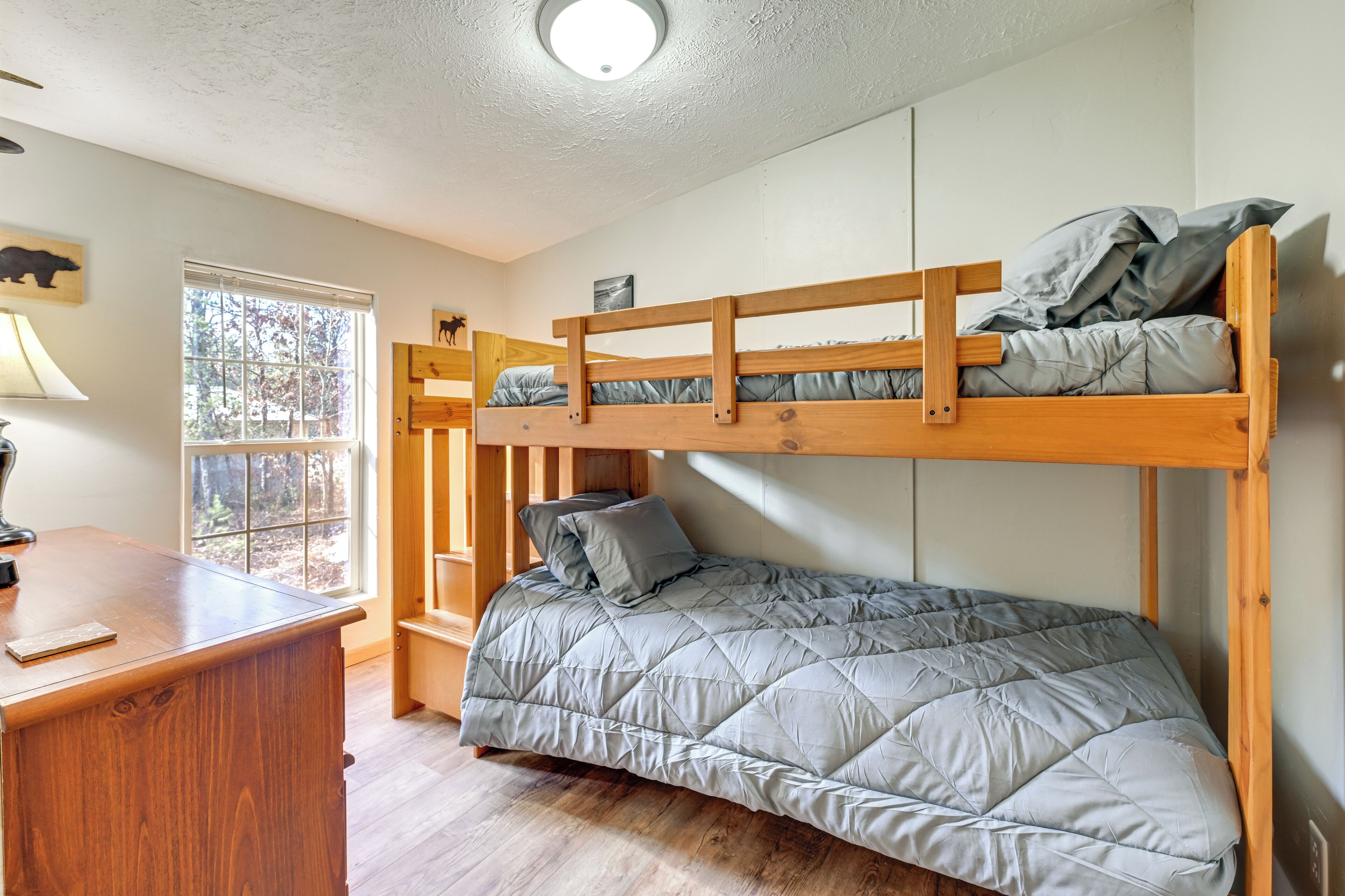 A bunk bed with a desk and a window.