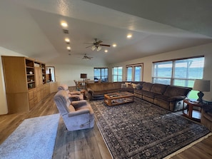 A spacious living room with a sectional sofa, a coffee table, and a fireplace. - Family Lakefront Home with Large Porch (Graham)