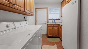 A compact kitchen with wooden cabinets, a white stove, and a built-in refrigerator.