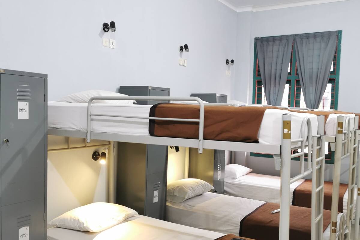 Habitación tipo dormitorio con literas, escritorio y armario.