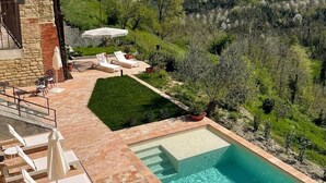 A pool area with lounge chairs and a view of a hilly landscape. - Relais Dal Cavaliere (Moncalvo)