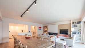Un espace de vie moderne comprenant un coin repas, une cuisine et un coin salon.