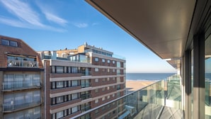 Un immeuble de grande hauteur doté de nombreux balcons donnant sur une plage.