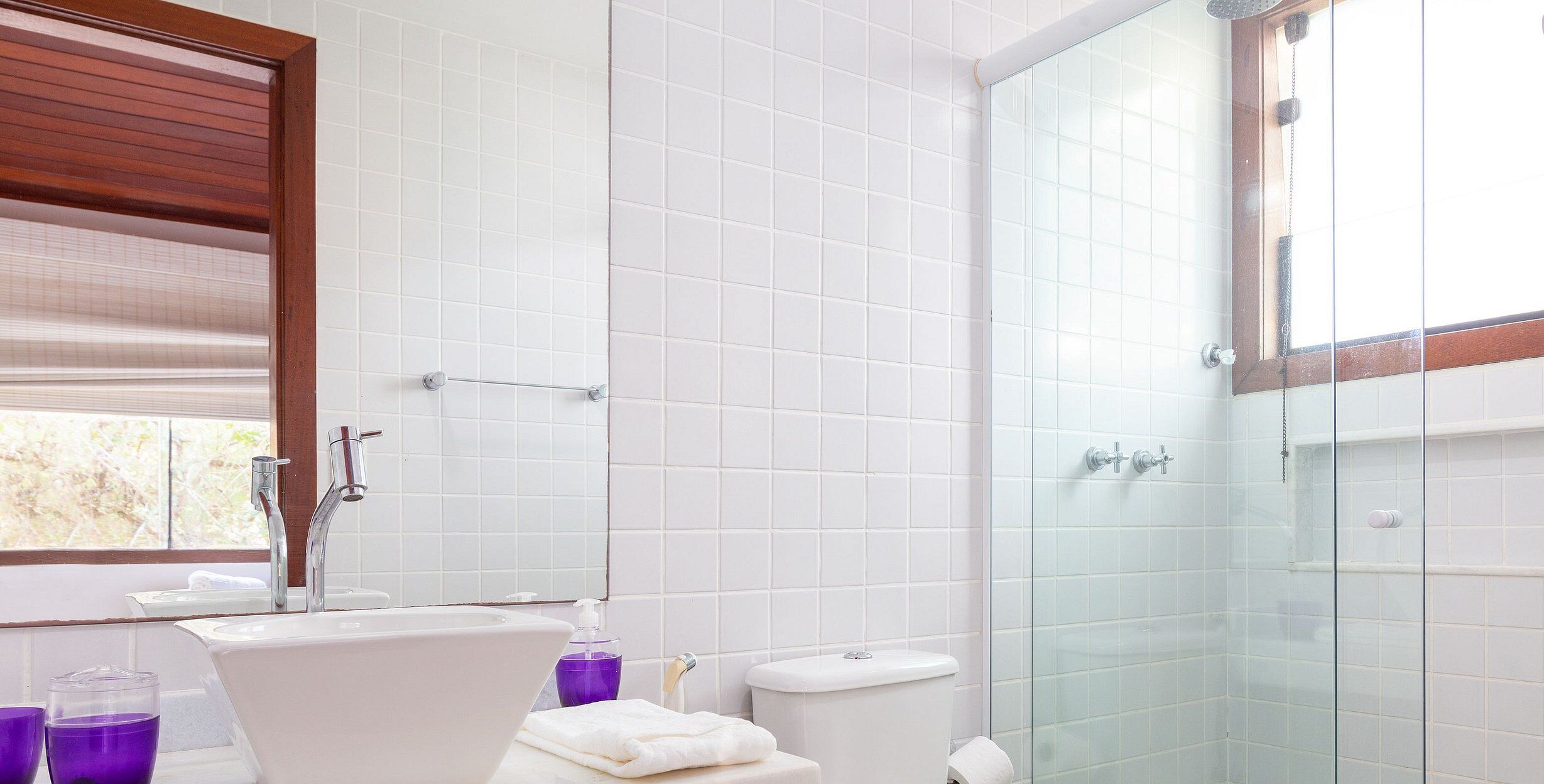 Ein Badezimmer mit Duschkabine, Waschbecken in Weiß und Toilette.