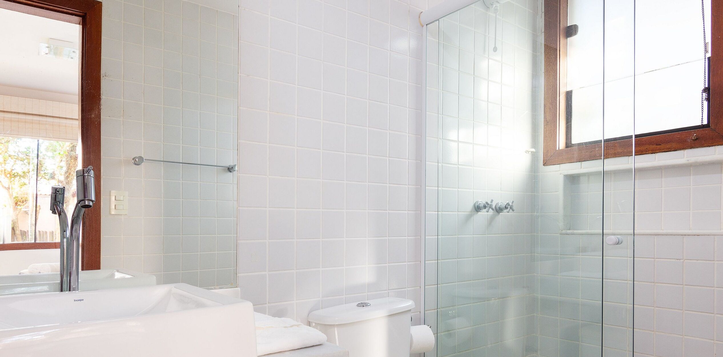 Une salle de bain avec une douche à parois de verre, un lavabo blanc et des toilettes.