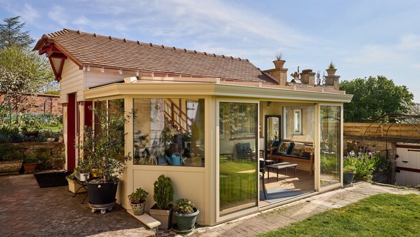 A glass-enclosed patio with a view of a garden and a patio chair. - Gîte between the Seine and the cliffs near GIVERNY and the Château de la Roche Guyon (Gommecourt)