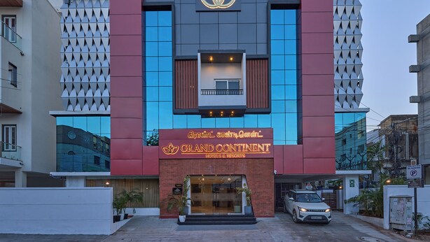 A modern hotel building with a prominent logo, a sign reading "Grand Continental Hotels & Resorts," and a car parked in front. - Grand Continent T Nagar (Chennai)
