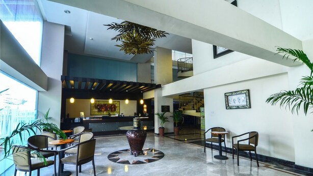 A spacious lobby with a central seating area, a reception desk, and a staircase leading to an upper level. - Losari Roxy Hotel Jakarta (Jakarta)