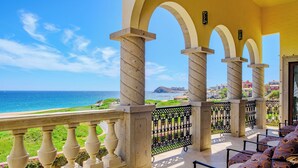 A balcony with a view of the sea, featuring a patterned sofa and a railing with decorative elements. - Luxury Cabo Del Sol Oceanfront Villa w/ Infinity Pool, Walk to Beach & Golf View (Corridor)