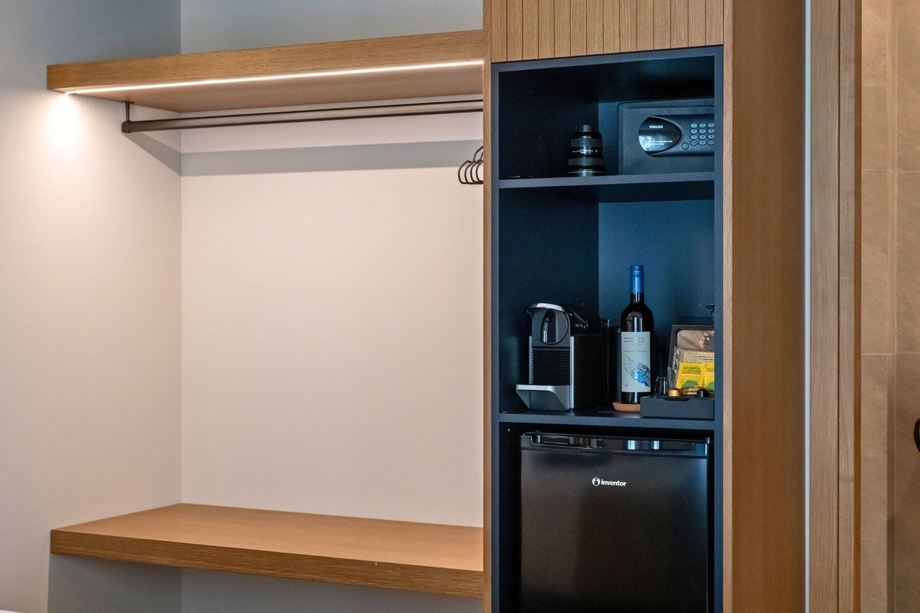 Eine Küche mit einem integrierten Kühlschrank, einer Kaffeemaschine und einer Weinflasche.