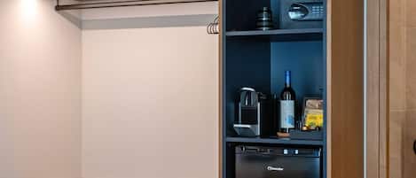 A kitchen with a built-in refrigerator, a coffee machine, and a wine bottle.