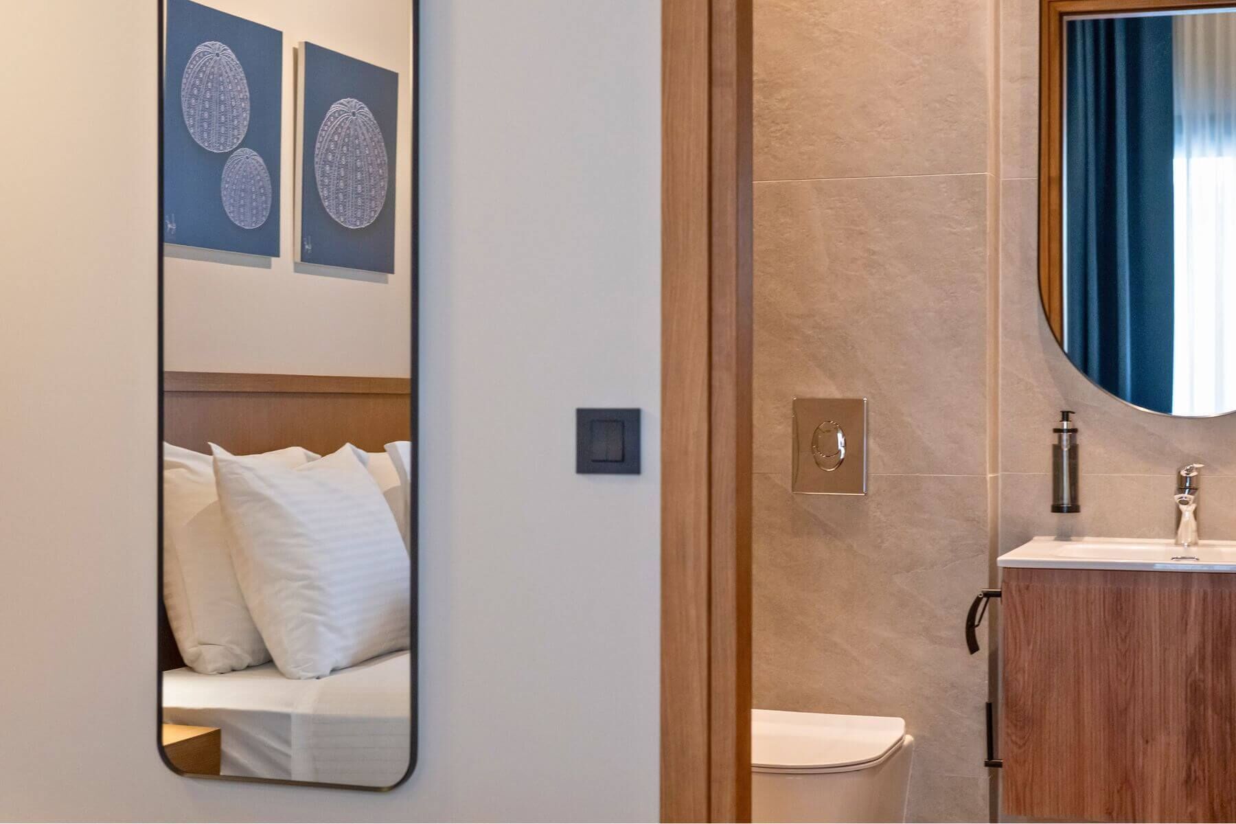 Een hotelkamer met een bed, een spiegel, een toilet en een wastafel.