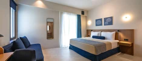 Una habitación de hotel moderna con una cama grande, un escritorio y un área de descanso.