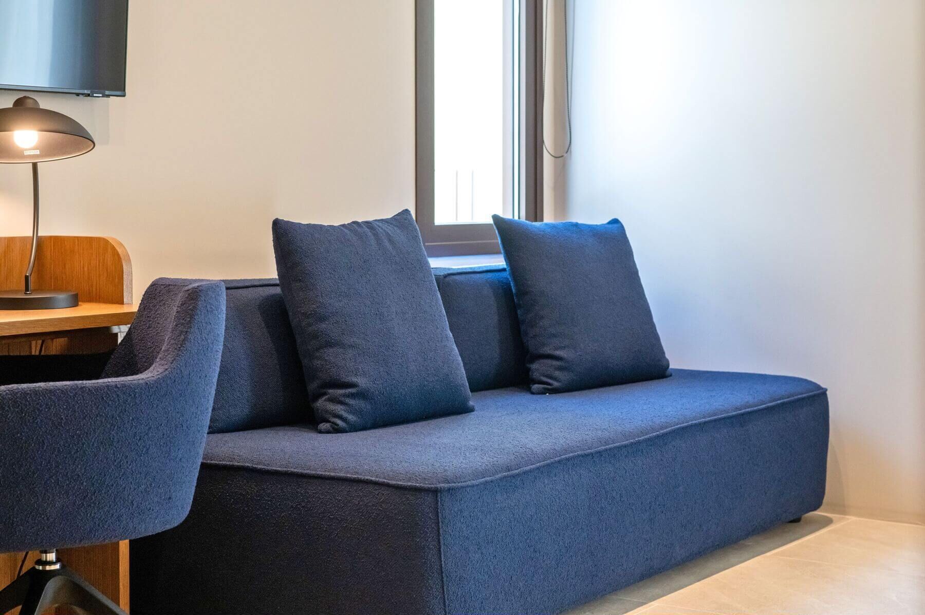 Ein modernes Zimmer mit einer Couch, einem Schreibtisch und einem Stuhl.