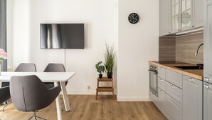 A modern kitchen with grey cabinets, a wooden countertop, and a built-in oven. - RentPlanet - Apartament Stawowa (Wroclaw)