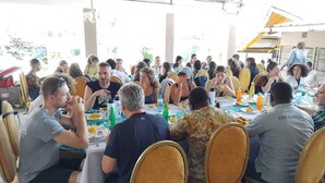 A group of people dining at an outdoor event with tables and chairs arranged in a semi-circle. - Olive Hotel Narok (Narok)