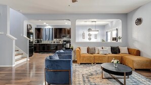 A modern living room with a sofa, armchairs, and a coffee table.