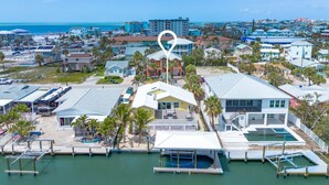 A coastal hotel with a marina, multiple buildings, and a view of the beach and ocean. - 218 Oasis On Ohio: Stunning Pool Home W/ Dock Access! 3 Bedroom Home (Fort Myers Beach)