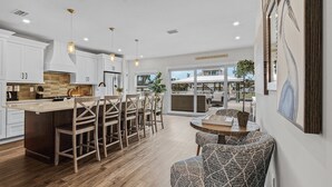 A modern kitchen with white cabinets, a large island, and pendant lighting. - 218 Oasis On Ohio: Stunning Pool Home W/ Dock Access! 3 Bedroom Home (Fort Myers Beach)