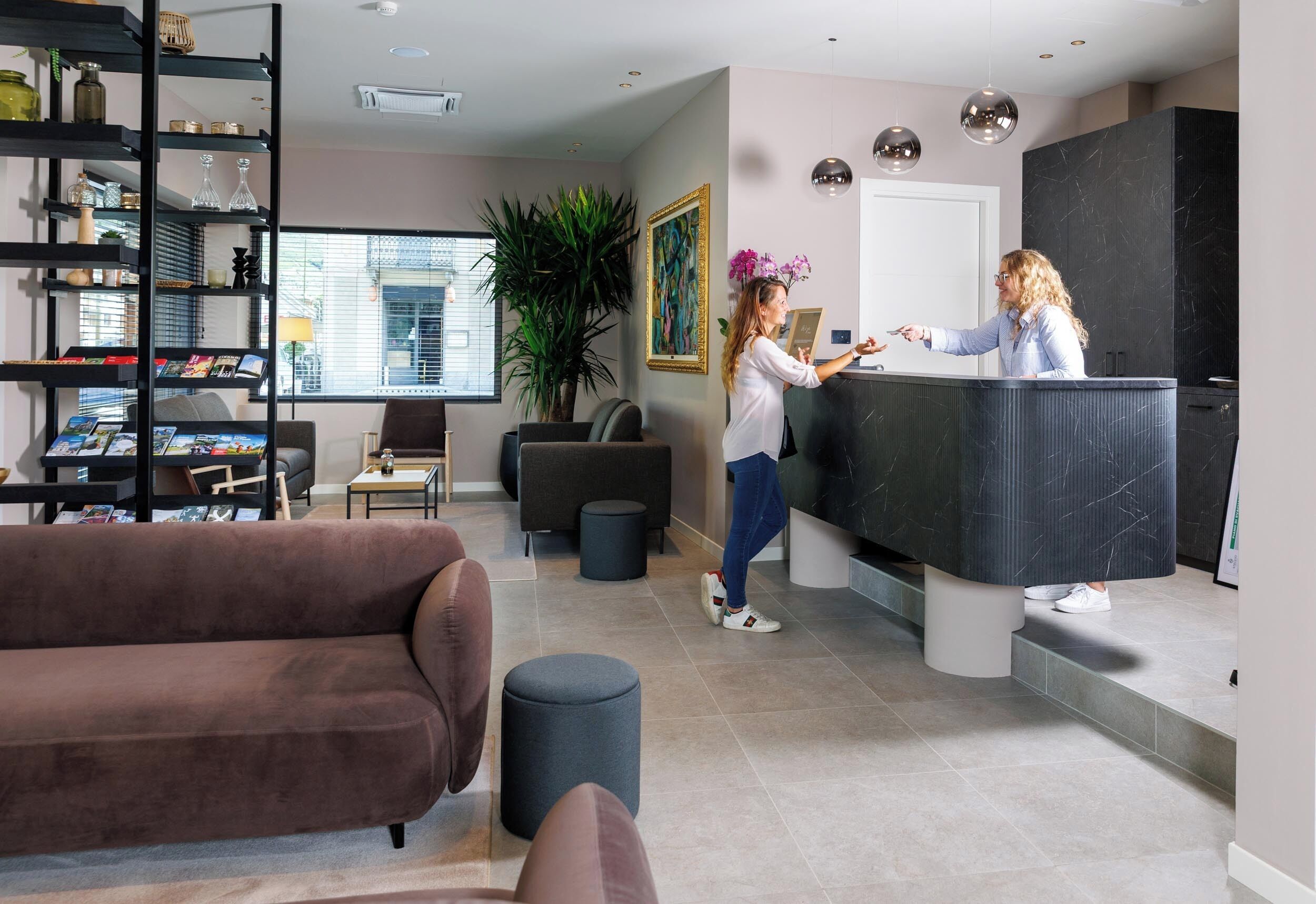 Un salon moderne avec un canapé marron, une table basse et une bibliothèque.