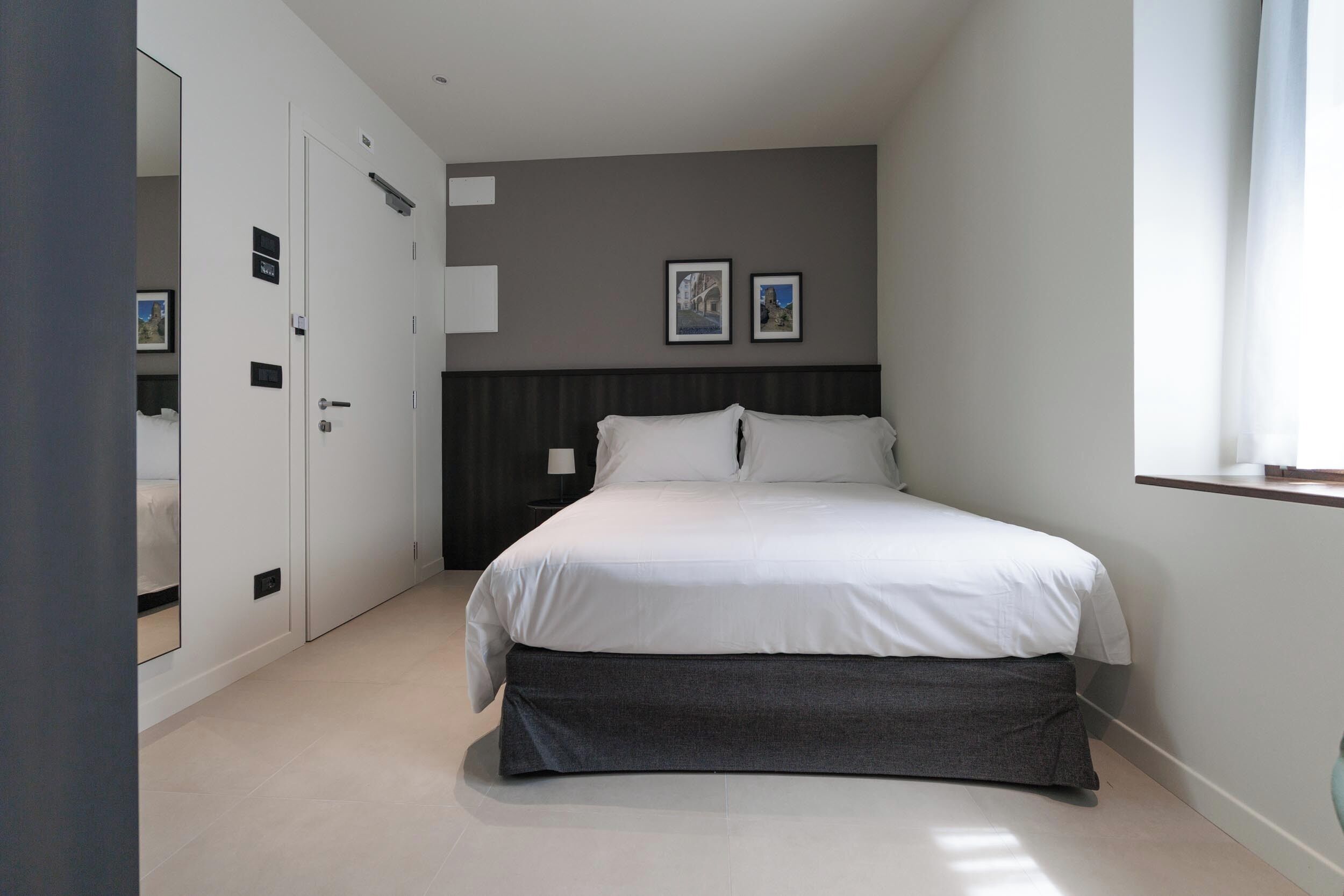 A bedroom with a bed, a wardrobe, and a nightstand.