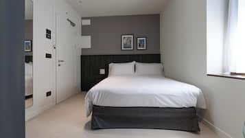 A bedroom with a bed, a wardrobe, and a nightstand.