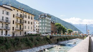 A hotel with a view of a river and mountains. - Hotel Stelvio Tirano (Tirano)