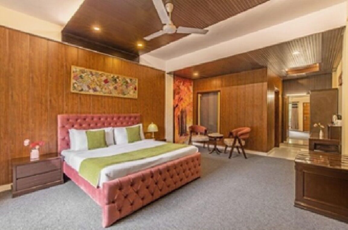 Ein Schlafzimmer mit einem großen Bett, einem Schreibtisch und einem Sessel.