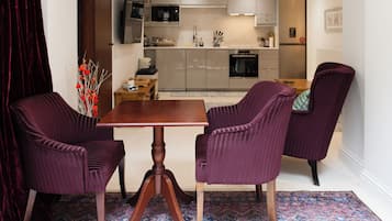 A modern kitchen with a dining area featuring a wooden table and purple upholstered chairs.