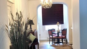 A hallway with a chandelier, a dining area with a table and chairs, and a decorative vase with tall grasses. - 21 Montpellier Terrace (Cheltenham)