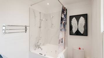 Ein modernes Badezimmer mit einer Duschkabine, einer weißen Badewanne und einer Toilette.