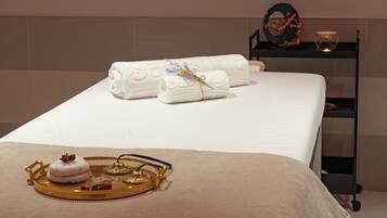 Relax in this serene hotel room featuring a comfortable bed, a stylish shelf, and thoughtful touches.